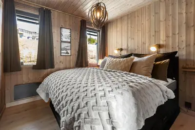 a bedroom with a large bed and a window at New modern apartment with ski in out in Hafjell in Hafjell