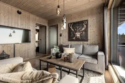 a living room with a couch and a table at New modern apartment with ski in out in Hafjell in Hafjell