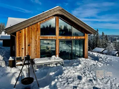 a log cabin in the snow with a bench at New modern cabin at Norefjell with sauna in Noresund