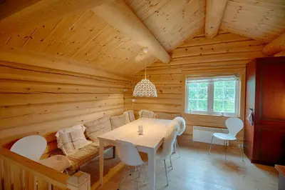 a dining room with a table in a wooden house at Peaceful Cabin Close To Beitostølen Center&Nature in Beitostøl
