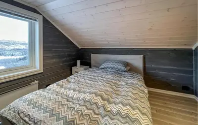 a bed in a small room with a window at Moderne Hytte Midt I Skibakken in Ryfoss