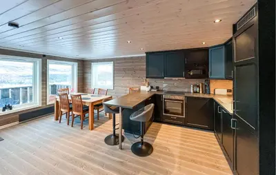 a kitchen with a table and a dining room at Moderne Hytte Midt I Skibakken in Ryfoss