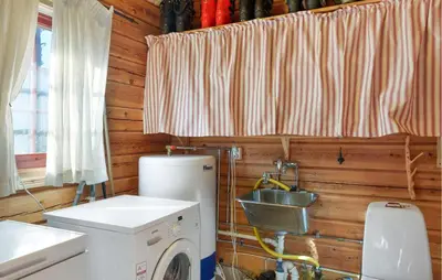 a kitchen with a washing machine and a window at Amazing Home In Hovet With Sauna in Hovet