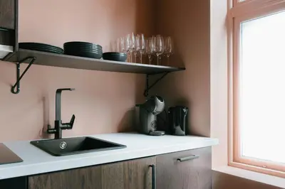 a kitchen with a sink and glasses on a shelf at New Apartment in Historical street in Bergen