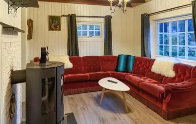 a living room with a red couch and a tv at 1 Bedroom Beautiful Home In Korssund in Korssund