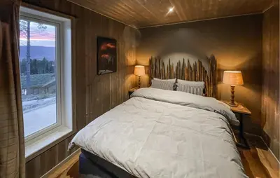 a bedroom with a large bed and a window at 4 Bedroom Gorgeous Home In Koppang in Koppang