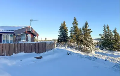 a house in the snow with a fence at Lovely Home In Sjusjøen With Wifi in Sjusjøen
