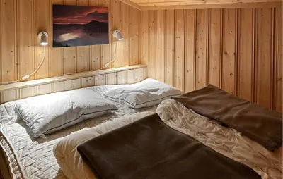 a bedroom with two beds in a wooden wall at Lovely Home In Sjusjøen With Wifi in Sjusjøen