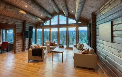a living room with couches and chairs and windows at Amazing Home In Koppang in Koppang