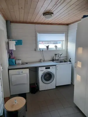 a kitchen with a washing machine and a sink at Ski WM Trondheim in Melhus