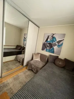 a room with a mirror and a bed and a couch at Villa 10 min walk from Ski World Championship in Trondheim