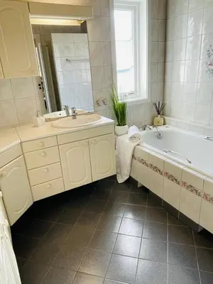 a white bathroom with a tub and a sink and a tub at Villa 10 min walk from Ski World Championship in Trondheim