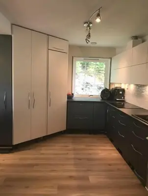 a kitchen with black and white cabinets and a window at Villa 10 min walk from Ski World Championship in Trondheim