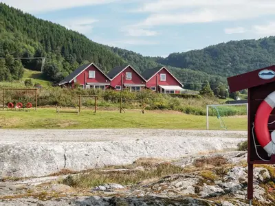 a group of houses on a hill with a soccer field at 4 person holiday home in Sørbøvåg in Sørbø