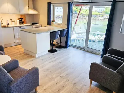 a kitchen with a counter and chairs and a table at 4 person holiday home in Sørbøvåg in Sørbø
