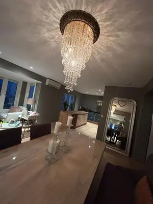 a dining table with a chandelier in a living room at Singsaker Panorama in Trondheim