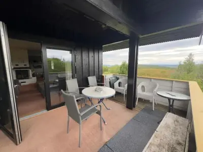 a house with a balcony with tables and chairs at Mountain Home With 5 Bedrooms And 2 Fireplaces in Beitostøl