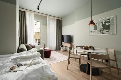 a bedroom with a bed and a table and chairs at VANDER Altona in Bergen