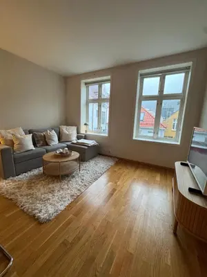 a living room with a couch and a table at Sentrumsnær trivelig leilighet in Bergen