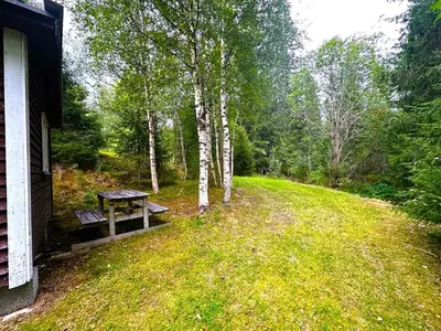 a picnic table sitting in the grass next to a house at Turifoss Camping Cabin 1 in Meråker