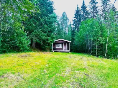a small cabin in the middle of a field at Turifoss Camping Cabin 1 in Meråker