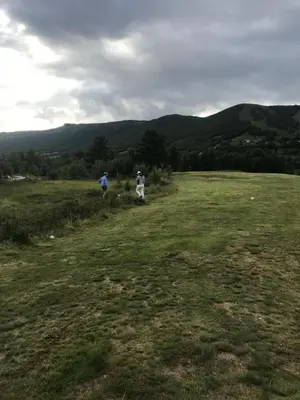 two people walking in a field with mountains in the background at Geilo sentrumsnær leilighet in Geilo