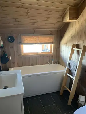 a bathroom with a tub and a window and a sink at Cozy Cabin With Fantastic Mountain Views In Oppheimåsen in Torpo