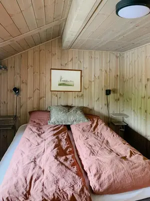 a bed in a room with a wooden wall at Cozy Cabin With Fantastic Mountain Views In Oppheimåsen in Torpo