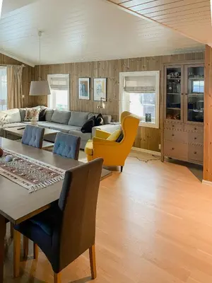 a living room with a couch and a table and chairs at Cozy Modern Cabin Near Sjusjøen in Mesnali