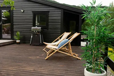 two chairs sitting on a deck in front of a cabin at Modern And Rustic Cabin With Fjord View In Samnanger in Årland