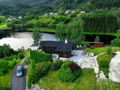 an aerial view of a house on a hill next to a lake at Modern And Rustic Cabin With Fjord View In Samnanger in Årland