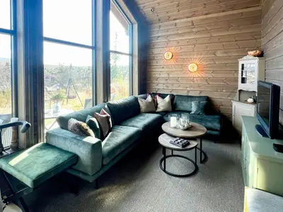 a living room with a green couch and a table at Family Cabin With Ski-Inski-Out In Trysil in Trysil