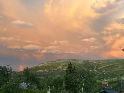 a rainbow in the sky over a mountain at Family Cabin With Ski-Inski-Out In Trysil in Trysil