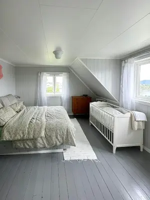 a white bedroom with a bed and a staircase at Idyllic Cabin At Bømlafjorden With Sea View in Mosterhamn