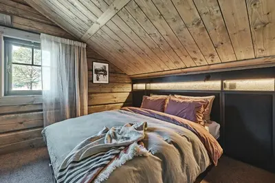 a bedroom with a bed in a wooden room at Luxury Cabin With Views in Stranda