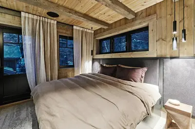a bedroom with a bed in a room with windows at Luxury Cabin With Views in Stranda