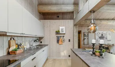 a kitchen with white cabinets and a wooden ceiling at Modern Cabin With Beautiful Design By Gålåvatn in Gålå