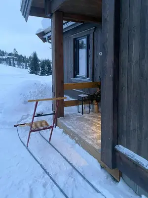 a bench sitting outside of a cabin in the snow at Modern Cabin With Beautiful Design By Gålåvatn in Gålå