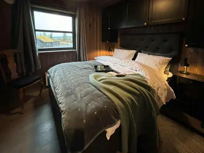 a bedroom with a large bed with a window at Modern Cabin With Views Of Skeikampen in Svingvoll