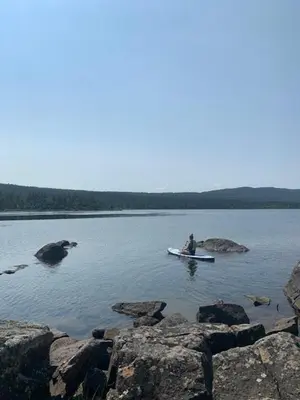 a person in a boat in the middle of a lake at Luxury Log Cabin By Hardangervidda in Uvdal