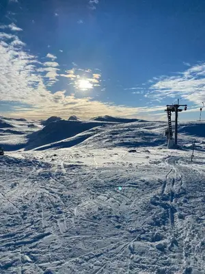 a snow covered slope with a ski lift in the distance at Luxury Log Cabin By Hardangervidda in Uvdal