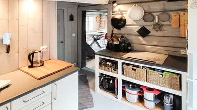 a kitchen with white cabinets and a counter with pots and pans at Idyllic Log Cabin With Ski-Inout At Dagalifjell in Uvdal