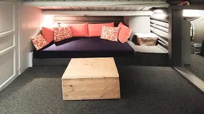a bed with pillows and a bench in a room at Idyllic Log Cabin With Ski-Inout At Dagalifjell in Uvdal