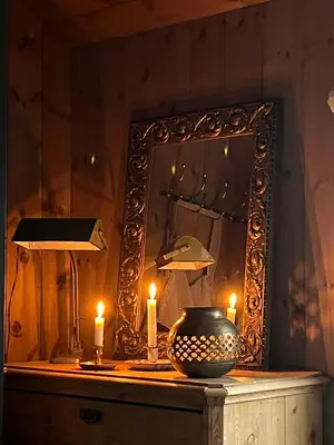 a mirror on a table with candles and a vase at Secluded Mountain Cabin In Rauland With View in Rauland