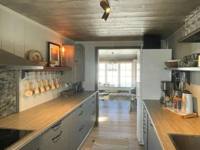a kitchen with white cabinets and a wooden floor at Secluded Mountain Cabin In Rauland With View in Rauland