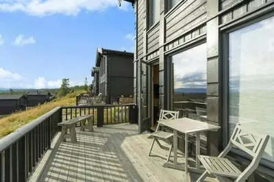 a balcony with two chairs and a table on it at Norefjell Cottage With Sauna And Whirlpool in Noresund