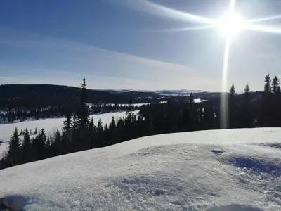 a snow covered hill with the sun in the sky at Ål Cabin With Panoramic Views in Favang