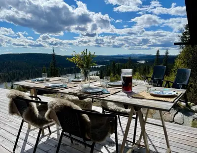 a wooden table with chairs on a deck with a view at Ål Cabin With Panoramic Views in Favang
