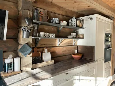a kitchen with white cabinets and wooden walls at Ørnenipa Lodge By Gaustatoppen With Panoramic View in Rjukan