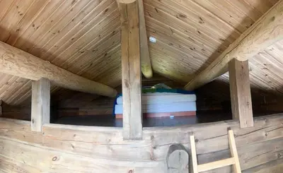 a wooden attic with a wooden ceiling and a ladder at Large Log Cabin, Ski Fun Near Dagali in Dagali